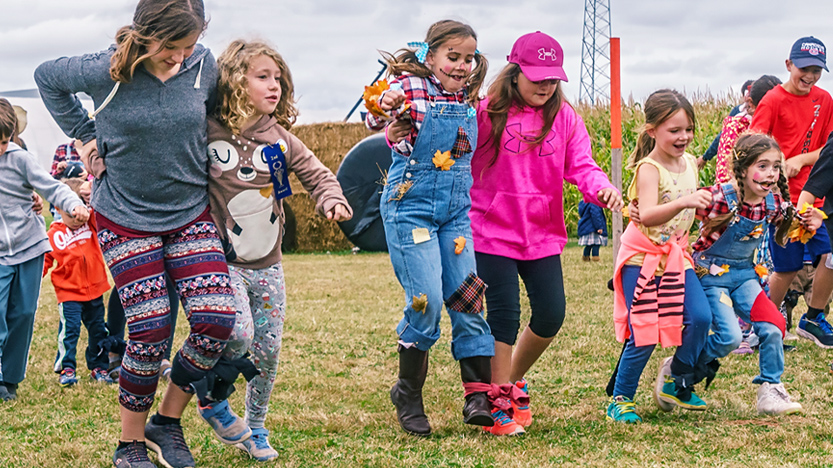 Crianças divertem-se a fazer uma gincana - corrida de pés atados