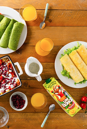 Wraps verdes acompanhados por tortilha e salada de frutas